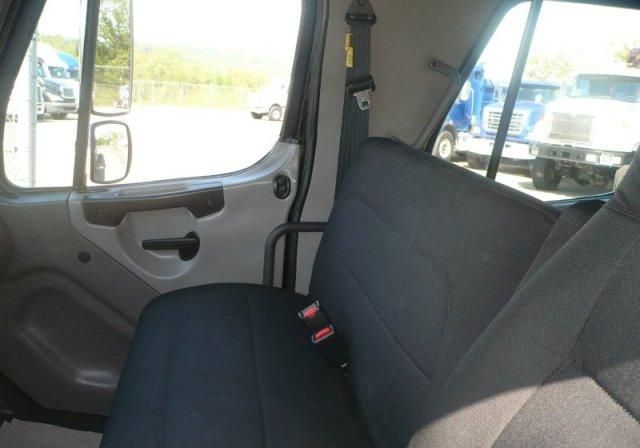 Freightliner M2 cab interior showing front bench seat and door panel.