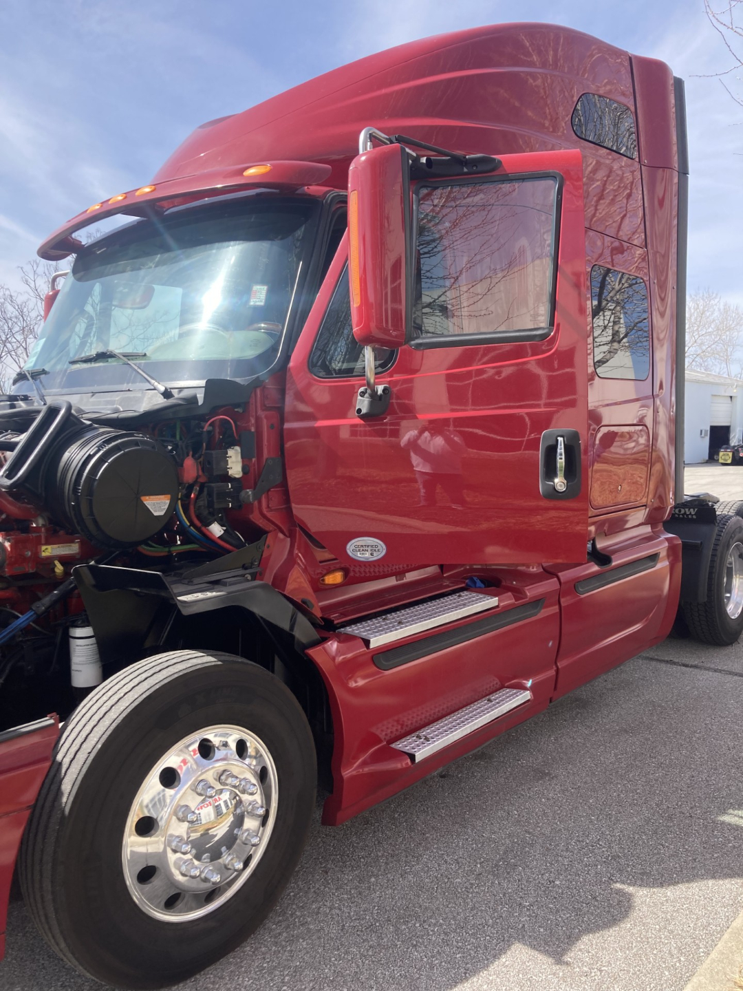 Red 2016 International Prostar conventional sleeper truck with cab door open showing engine bay and exposed components.