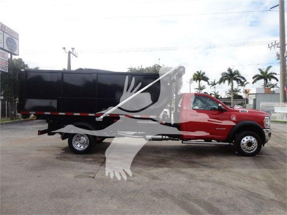 Ram 5500 SLT truck with a black hooklift body and red cab, side view.