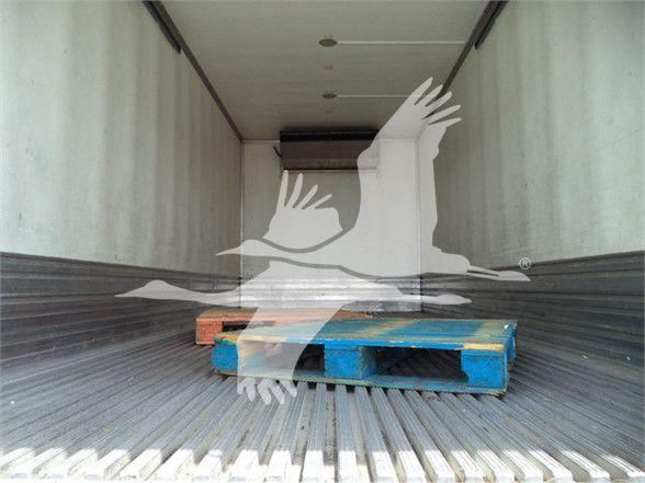 Interior view of a reefer truck trailer with a blue wooden pallet inside