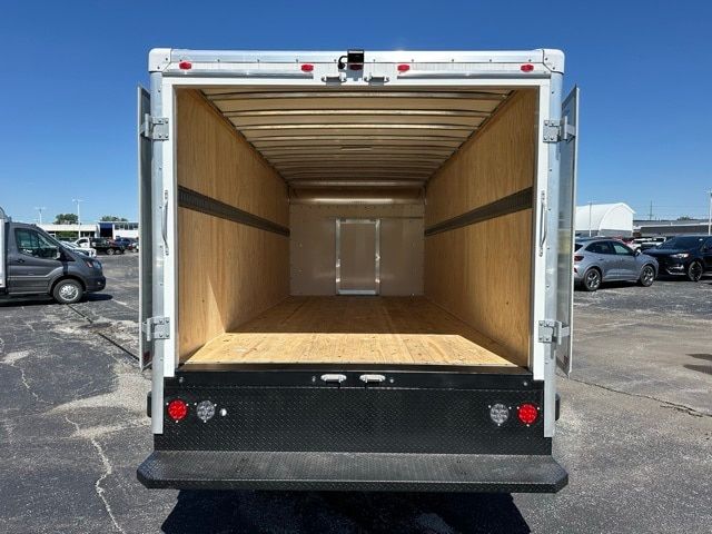 Box truck cargo area showing empty wooden interior with rear doors open.