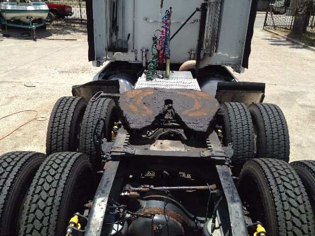 Truck chassis with fifth wheel area and dual rear axles; visible tires and frame components; some rust on a circular platform on top of the frame.