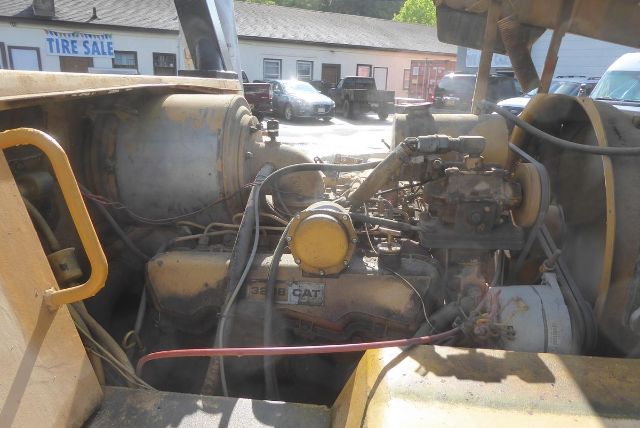 Caterpillar V225 truck lift engine bay showing Caterpillar engine block and yellow circular component with hoses and a turbo/air system.
