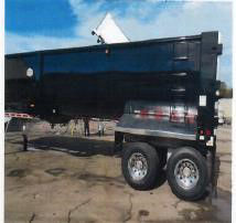 Dump trailer showing a 40ft steel frameless half-round dump with dual rear axles and black/gray color