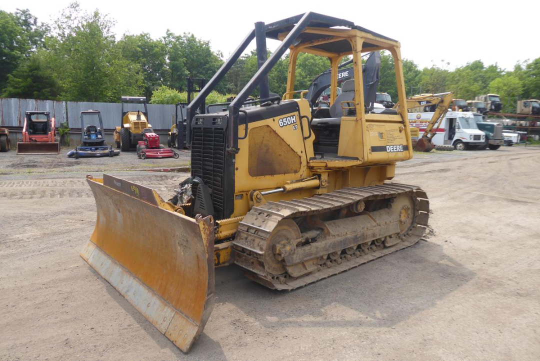 John Deere 650HLT crawler dozer with large blade, tracked undercarriage, open operator cab, serial badge 650H on side.