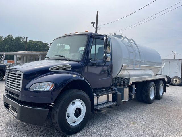 Truck tank body Freightliner M2 blue cab with large stainless steel septic tank on rear.
