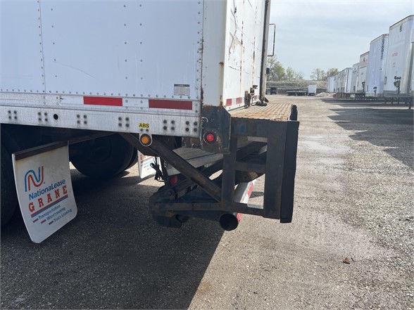 Rear end of a 2004 Wabash dry van trailer showing rear bumper and discharge area with landing gear and a fendered mudflap.