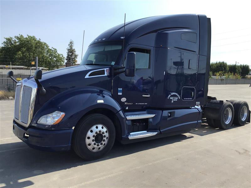 Kenworth T680 tractor with sleeper, navy blue, side view showing cab highlights and fuel steps.