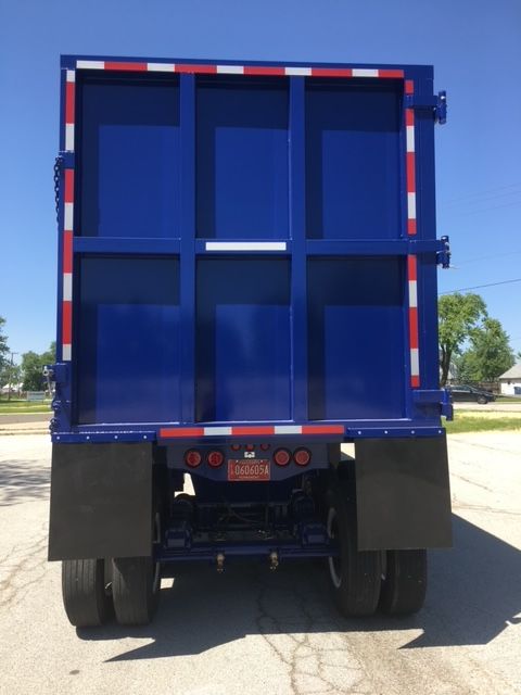Blue 40 ft square dump trailer rear view showing hydraulic dump bed doors and dual rear tires.