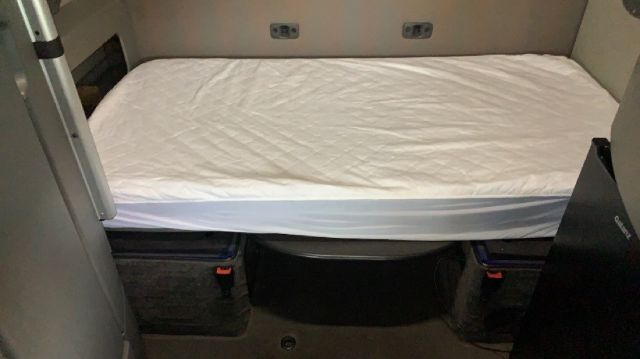 Volvo truck sleeper bunk area with mattress and storage compartments visible.