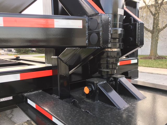 Chassis of 2003 Wabash tipper trailer showing hydraulic leg and frame with safety reflectors and bolts.