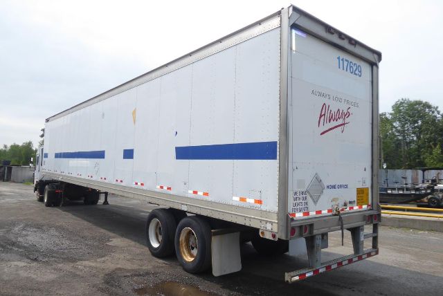 Great Dane trailer showing white body with blue stripe, dual rear wheels, and Always Low Prices Always branding on the back door; side view with trailer hitch and tires.
