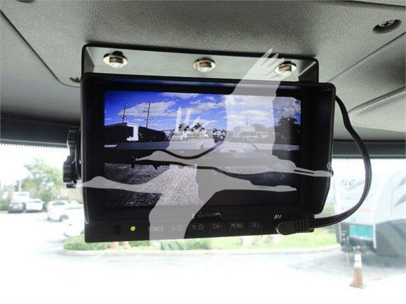 In-vehicle monitor screen mounted on ceiling showing rear view camera display.