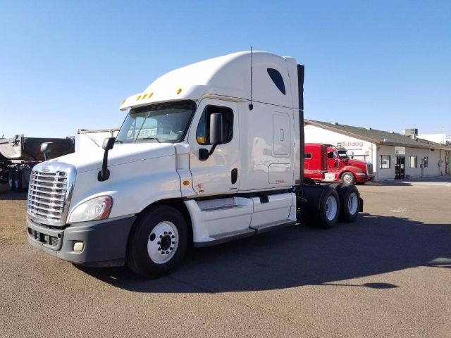 Truck cab in daylight showing a white 2012 Freightliner Cascadia conventional sleeper with a high roof, front grille, and side mirrors.
