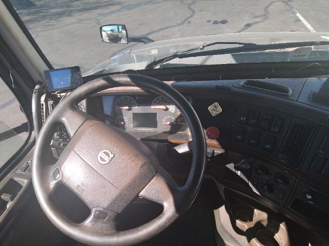 Volvo truck sleeper interior showing steering wheel and dashboard with gauges and control panels.