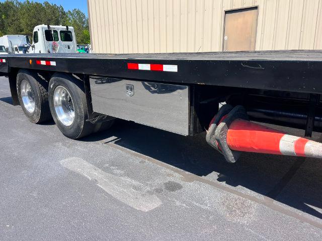 2015 Peterbilt 348 rollback truck side view showing toolbox and dual rear wheels with a red safety boom hose.