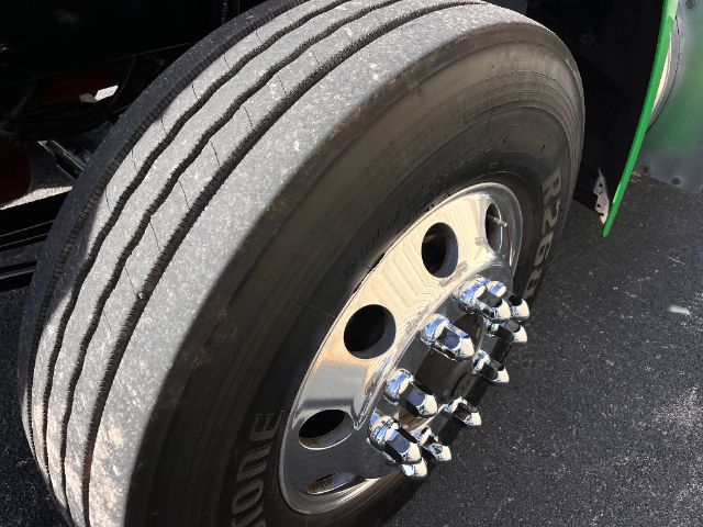 Truck wheel and tire assembly on a 2018 Peterbilt 579 conventional daycab showing a chrome dual-axle hub with lug nuts.