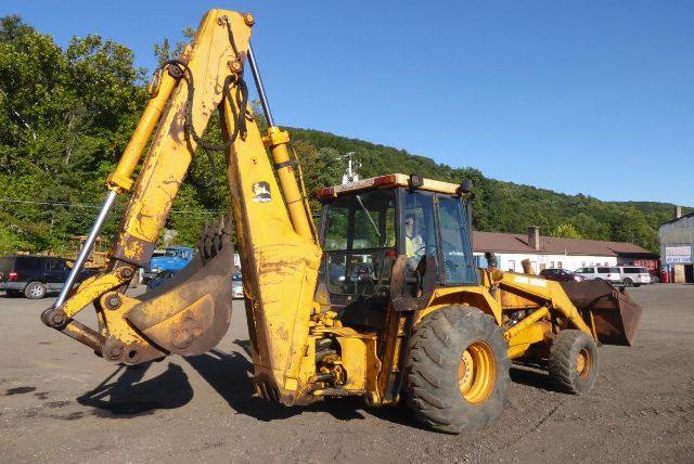 1986 John Deere 710B backhoe loader with front loader and rear digging arm, yellow paint, large tires, VIN T0710BJ731912, stock 0910201.