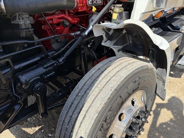 International Lonestar truck engine bay and front wheel showing red engine components and dual front tires.