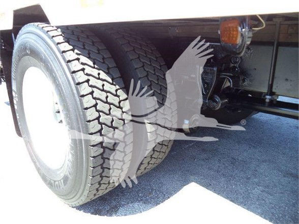 Rear dual tires of a reefer truck showing wheel, suspension and frame components.