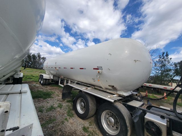 Tank trailer for Freightliner Cascadia with cylindrical white tank on dual-axle trailer, T6314 marking visible.