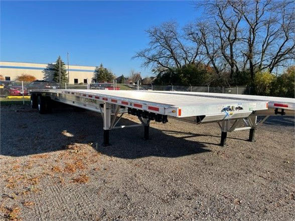 Flatbed trailer showing aluminum Fontaine Revolution 52-53 ft with dual axles and landing gear, side rails, and reflective tape.
