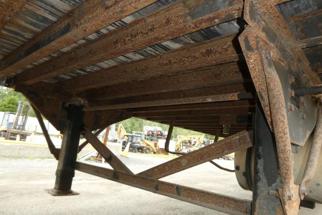 Great Dane trailer undercarriage showing rusted steel frame, support legs, and wheel hub.