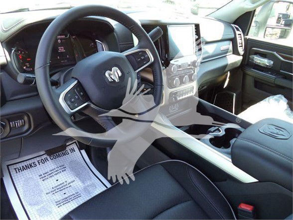 Ram pickup interior showing steering wheel and center console with touchscreen display.
