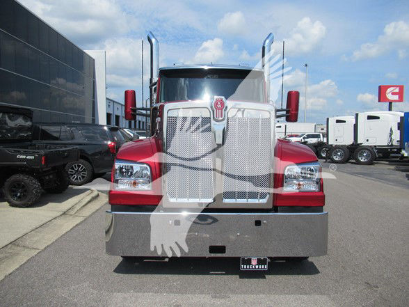 Front view of a red Kenworth W990 truck with large chrome grille, square headlights, chrome bumper, and oversized mirrors.
