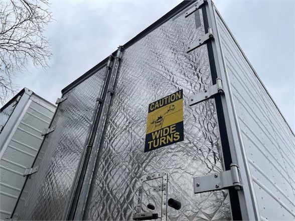 2024 CIMC Cool Globe Reefers trailer rear door with caution wide turns sticker and diamond plate pattern.