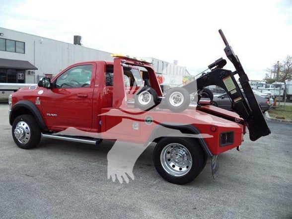 Red 2021 Ram 4500 SLT tow truck with a flatbed; side view shows 4x4 Ram badge, chrome wheels, and a hydraulic bed; stock/tow equipment visible
