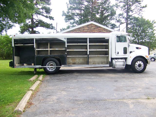 Peterbilt 335 dump truck side view showing open cargo compartments and steel shelving.