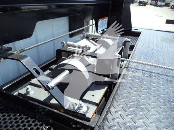 Ram 5500 tow truck bed mechanism with winch and securing hardware mounted on diamond plate platform.