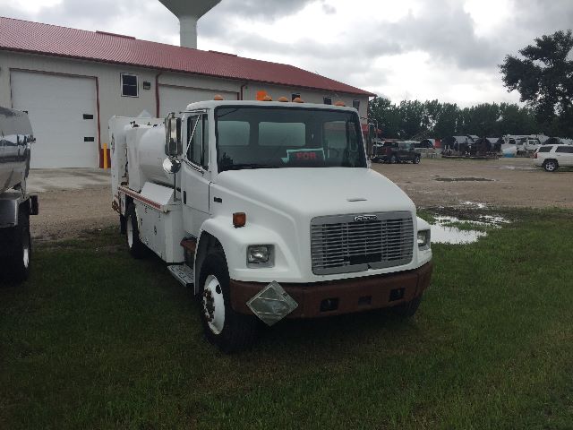 White 2003 Freightliner FL-70 gasoline service truck with utility components, front grille, and brown bumper.