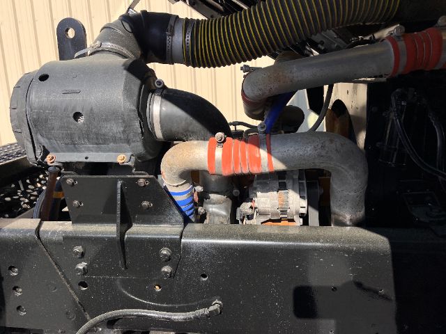 Engine bay showing large blower housing and intake plumbing with hoses and clamps on Kalmar Ottawa truck engine.