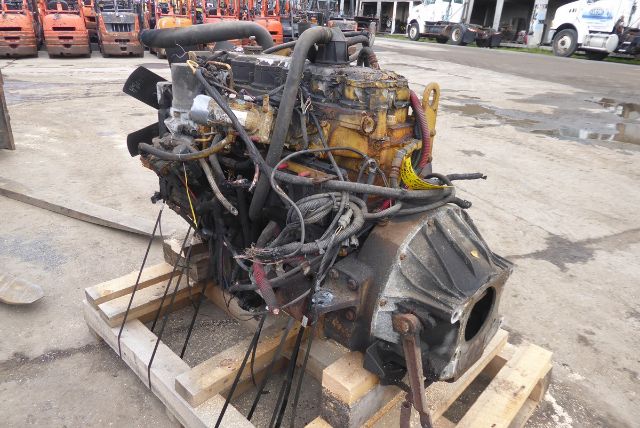 Engine with numerous hoses and wiring on a pallet-mounted block with a bolted transmission housing.
