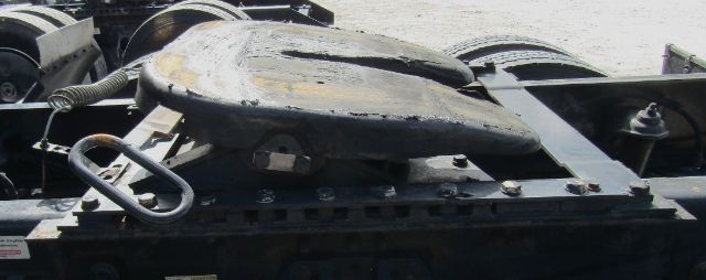 Kenworth T680 cab and chassis showing inspection hatch and mounting hardware on a flatbed frame.