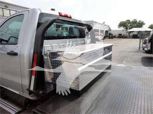 Chevrolet Silverado 6500HD flatbed truck with diamond plate toolbox on the bed and side steps visible.