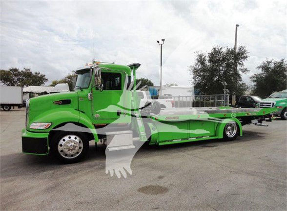 2022 Peterbilt 337 tow truck, bright green with white accents, side view showing long wheelbase and flatbed/recovery equipment.