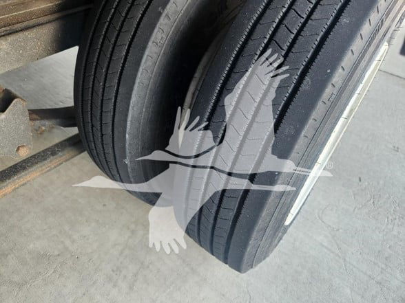 Dual trailer wheels and tires showing tread pattern and sidewall details.