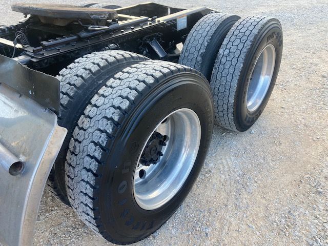 Truck rear dual tires on Mack CXU613 tractor showing dual rear axles and tire treads.