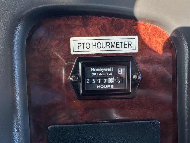 PTO hourmeter and Honeywell quartz hour meter display mounted in a wood-grain panel with the label PTO HOURMETER above.