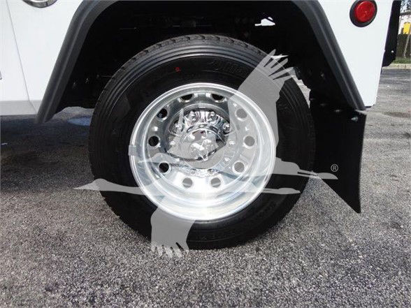 Ram 5500 SLT front wheel showing polished steel wheel and tire, with black fender and wheel well; watermark with airplane graphic overlay.