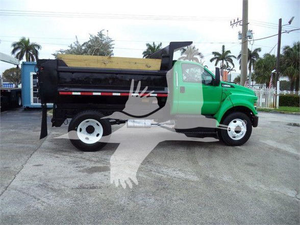 2017 Ford F650 SD dump truck side view showing dump bed, green cab, white wheels, and black chassis.
