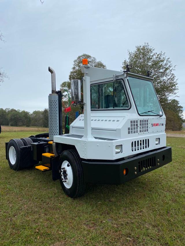 Kalmar Ottawa yard truck cab view showing white body, black bumper, orange beacon, with visible exhaust stack and steps.