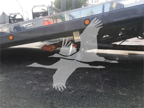 Tow truck trailer with Peterbilt 337 undercarriage showing a sticker or label on the frame and a shadow of a seagull overlay. Visible text includes 'Peterbilt' on a side panel and a partial '337' model marking.