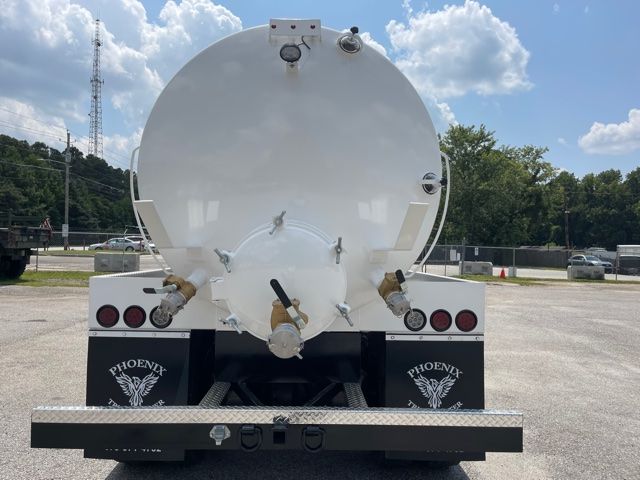 Rear view of a 2013 Freightliner M2 septic/sewer service truck with a large cylindrical tank and Phoenix mud flaps, showing hoses and fittings.