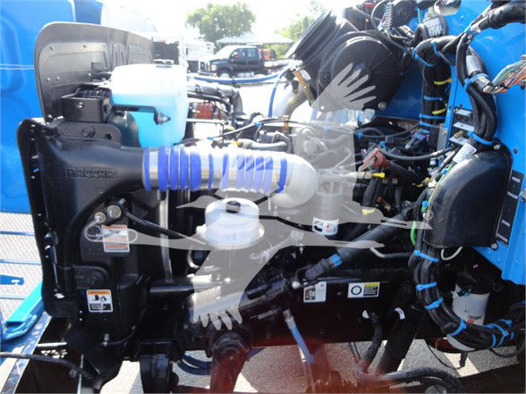 Peterbilt 337 engine bay showing cooling reservoir and various hoses and wiring harnesses.