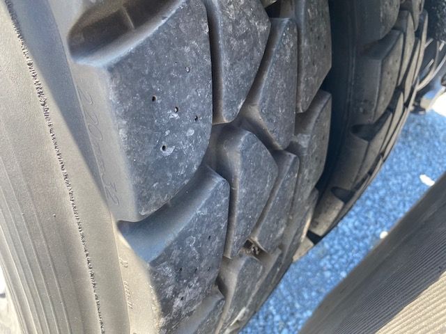 Tire tread close-up on a 2017 Ottawa T2 showing heavy-duty truck tire with deep grooves.