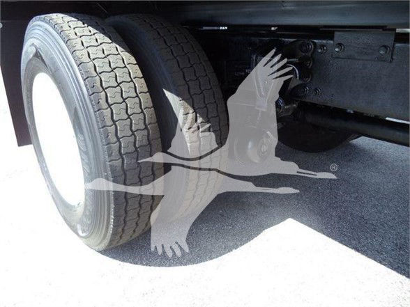 Truck wheel and dual rear tires showing undercarriage with suspension and frame visible.